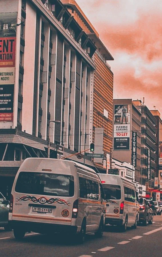A busy urban commercial corridor with buildings and public transport